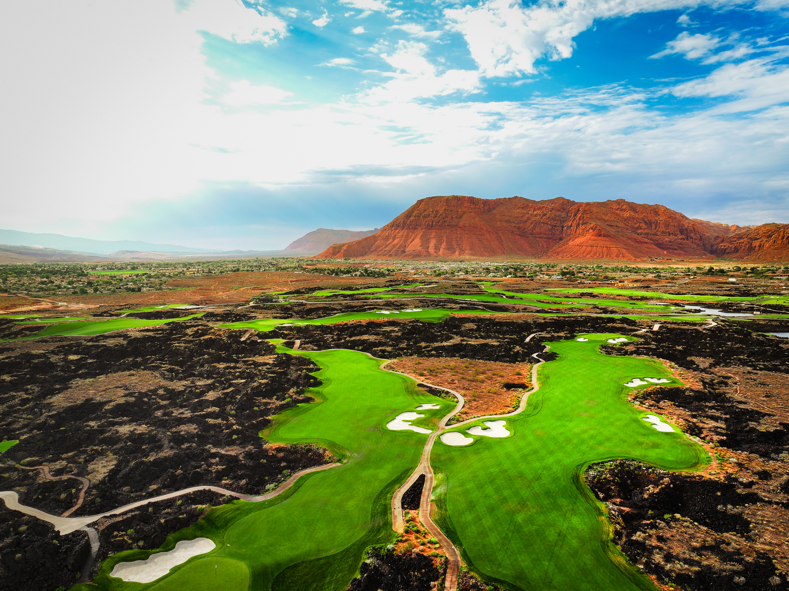 Drone aerial view of Black Desert Resort golf hole with canyon and red rock backdrop